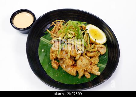 Knusprig gebratener Tintenfisch oder Calamari auf einem Teller mit weißem Hintergrund Stockfoto