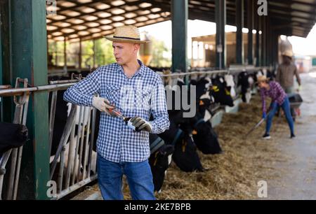 Landwirt mit Spritze und Medizin in den Händen auf dem Milchviehbetrieb Stockfoto