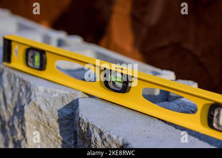 Während des Baus der Stützmauer auf dem neuen Grundstück ist Nivellierwerkzeug während des Baus. Stockfoto