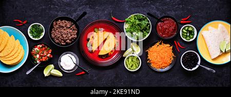 Taco Bartisch-Szene mit einer Auswahl an Zutaten. Draufsicht auf einem dunklen Schieferbanner Hintergrund. Mexikanisches Buffet. Stockfoto