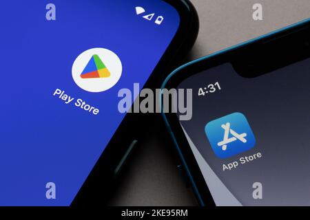 Symbole von Google Play Store und Apple App Store werden jeweils auf einem Google Pixel Smartphone und einem iPhone angezeigt. Google Play im Vergleich zum Apple App Store. Stockfoto