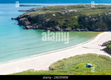 Schottischer Campingplatz, atemberaubender Sand, ruhiges, azurblaues atlantisches Meer, sonniger Sommermorgen, mit Gras bewachsen, unter dem Beinn Ceannabeinne Berg, wunderschöne Stockfoto