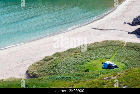 Schottischer Campingplatz, atemberaubender Sand, ruhiges, azurblaues atlantisches Meer, sonniger Sommermorgen, mit Gras bewachsen, unter dem Beinn Ceannabeinne Berg, wunderschöne Stockfoto