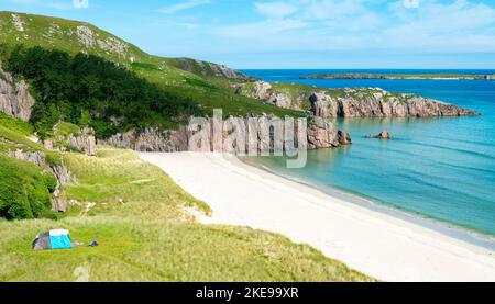 Schottischer Campingplatz, atemberaubender Sand, ruhiges, azurblaues atlantisches Meer, sonniger Sommermorgen, mit Gras bewachsen, unter dem Beinn Ceannabeinne Berg, wunderschöne Stockfoto