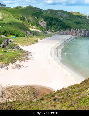 Schottischer Campingplatz, atemberaubender Sand, ruhiges, azurblaues atlantisches Meer, sonniger Sommermorgen, mit Gras bewachsen, unter dem Beinn Ceannabeinne Berg, wunderschöne Stockfoto