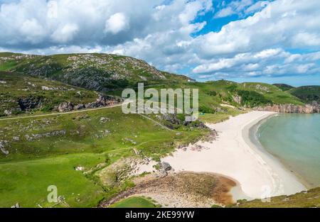 Schottischer Campingplatz, atemberaubender Sand, ruhiges, azurblaues atlantisches Meer, sonniger Sommermorgen, mit Gras bewachsen, unter dem Beinn Ceannabeinne Berg, wunderschöne Stockfoto