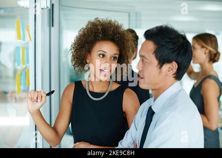 Einen schlechten Schritt zu machen oder zu brechen kann Ihr Unternehmen. Kollegen mit Haftnotizen gegen die Wand während einer Brainstorming-Sitzung. Stockfoto