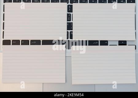 Leere Visitenkarten über der Laptop-Tastatur mit Kopierplatz oder leere Bilderrahmen über einer Tastatur Stockfoto