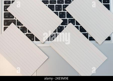 Leere weiße Karten mit Textzeilen über einer Laptop-Tastatur Stockfoto