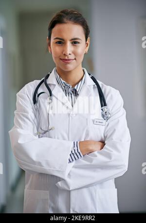 Shes bekam das Vertrauen, das Sie sich in einem Arzt wünschen. Porträt einer selbstbewussten jungen Ärztin, die ihre Arme kreuzt. Stockfoto