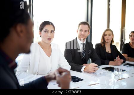 Sie alle konzentrierten sich auf den Erfolg. Eine Gruppe von Geschäftskollegen trifft sich im Sitzungssaal. Stockfoto