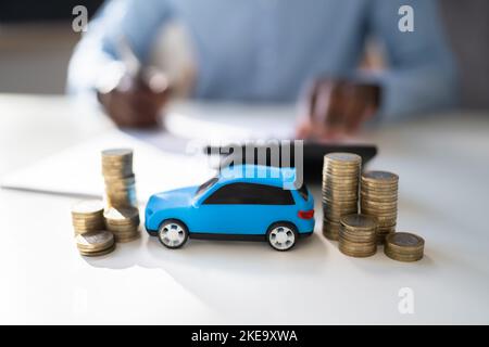 Spielzeugauto Vor Geschäftsmann, Der Darlehen Berechnet Stockfoto