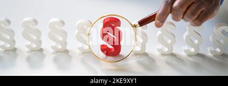 Nahaufnahme Der Hand Des Geschäftsmannes Mit Dem Roten Absatzschild Mit Lupe Auf dem Holztisch Stockfoto