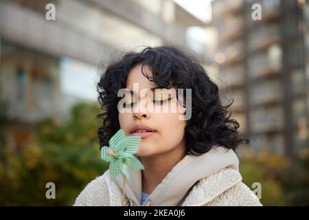 Teenager Mädchen weht auf Windrad Stockfoto