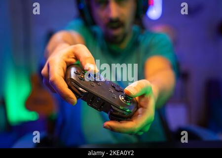 Moderner Gamer spielt Videospiele mit Gamepad auf einem technologischen Raum Unterhaltung, Cyberspace. Stockfoto