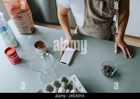 Mittlere Abteilung der Frau, die das Handy benutzt Stockfoto