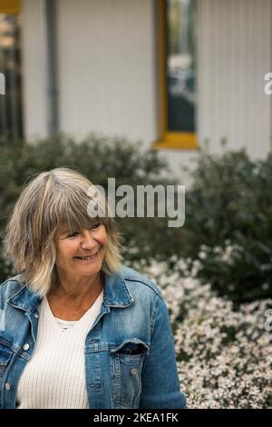 Lächelnde ältere Frau in einem Wohngebiet Stockfoto