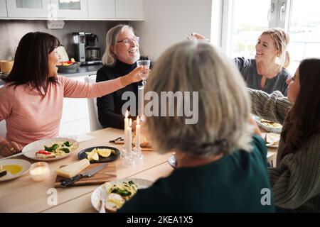 Die Familie rastet beim Abendessen Toast auf Stockfoto