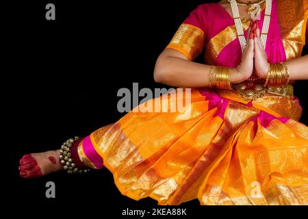 Klassische indische Tänzerin, die Bharatanatyam-Tanz vorführt, posiert im dunklen Hintergrund mit Kopierbereich. Stockfoto