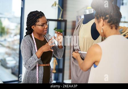 Wissen Sie, was Sie wollen und wie Sie es kommunizieren können. Modedesigner, die an einem neuen Design messen. Stockfoto