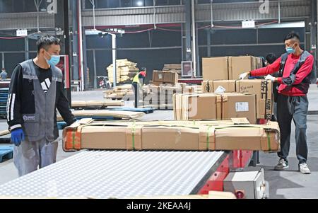 XUZHOU, CHINA - 11. NOVEMBER 2022 - Mitarbeiter des SF Express Distributionszentrums sortieren Waren für die Verladung in einem E-Commerce-Logistikpark in Xuzhou, Stockfoto