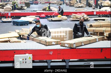 XUZHOU, CHINA - 11. NOVEMBER 2022 - Mitarbeiter des SF Express Distributionszentrums sortieren Waren für die Verladung in einem E-Commerce-Logistikpark in Xuzhou, Stockfoto