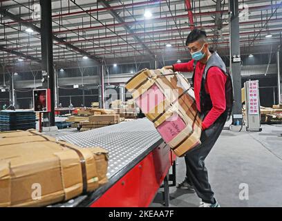 XUZHOU, CHINA - 11. NOVEMBER 2022 - Mitarbeiter des SF Express Distributionszentrums sortieren Waren für die Verladung in einem E-Commerce-Logistikpark in Xuzhou, Stockfoto