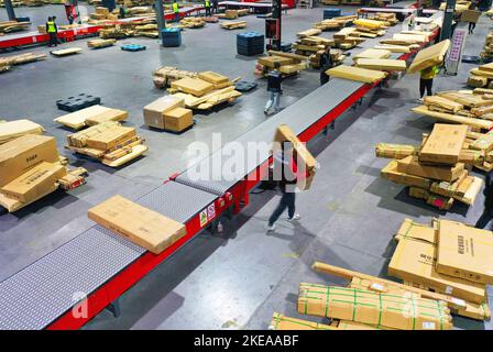 XUZHOU, CHINA - 11. NOVEMBER 2022 - Mitarbeiter des SF Express Distributionszentrums sortieren Waren für die Verladung in einem E-Commerce-Logistikpark in Xuzhou, Stockfoto