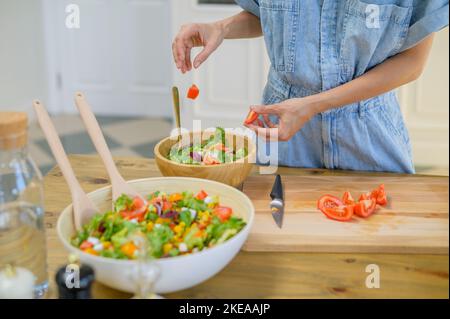Crop Frau bereitet gesunden Salat in der Küche Stockfoto