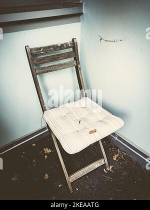 Alter Klappstuhl in der Ecke eines Hauses Stockfoto