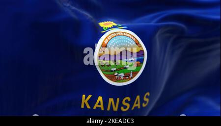 Nahaufnahme der Kansas State Flag, die im Wind winkt. Kansas ist ein Bundesstaat im Mittleren Westen der Vereinigten Staaten. Texturierter Hintergrund aus Stoff. Selektiver Fokus. Stockfoto