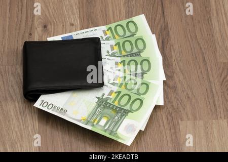 500 Euro ragen aus der Brieftasche. Fünf Papierbanknoten zu je 100 Euro. Symbol für wachsende Ausgaben, Inflation, Zahlung von Haushaltsrechnungen, Gehalt. Stockfoto