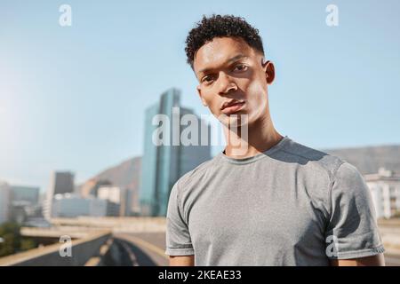Junger schwarzer Mann und Porträt auf Brücke mit Gebäuden, Himmel und Stadt zum Laufen. Mann, Fitness und Training in der Stadt, in der Metro oder in der Stadt bei sommerlicher Sonne Stockfoto