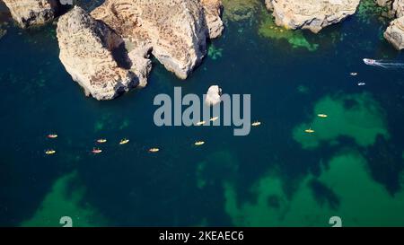Luftdrohnenaufnahme von Booten und Kajaks im Atlantischen Ozean, Lagos, Algarve, Portugal. Erkundung von Höhlen und Tunneln. Reisen und Abenteuer. Feiertage. Stockfoto