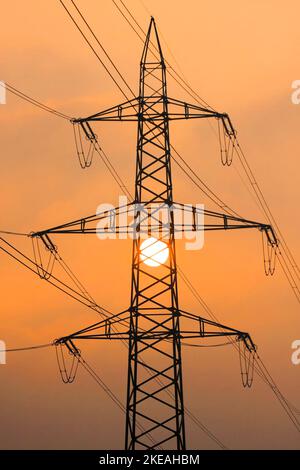 Untergehende Sonne hinter den Silhouetten der aktuellen Pole, Schweiz Stockfoto