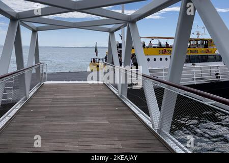 Passagiere, die eine kleine Brücke überqueren, fahren für eine Tour auf die Fähre Stockfoto