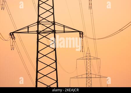 Untergehende Sonne hinter den Silhouetten der aktuellen Pole, Schweiz Stockfoto