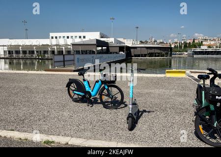 Elektrofahrräder und E-Scooter auf dem Pier geparkt Stockfoto