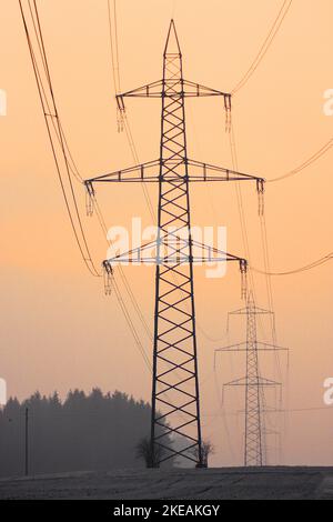 Untergehende Sonne hinter den Silhouetten der aktuellen Pole, Schweiz Stockfoto