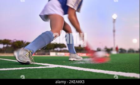 Sport, Hockey und Hit mit Frau auf dem Feld für Training, Fitness und Ziele Übung. Herausforderung, Action oder Power mit den Schuhen des Eishockeyspielers im Stadion Stockfoto