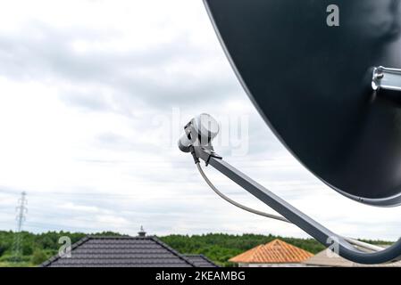 Schornsteinhalter zur Montage einer Satellitenschüssel am Schornstein, sichtbarer Konverter mit Kabel. Stockfoto