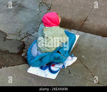 Bettler von oben auf dem Bürgersteig Stockfoto