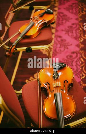 Detailansicht von zwei Violinen auf einigen Stühlen. Stockfoto