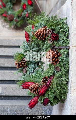 winterweihnachtskranz mit natürlichen Blumen, Pflanzen und Zapfen Stockfoto