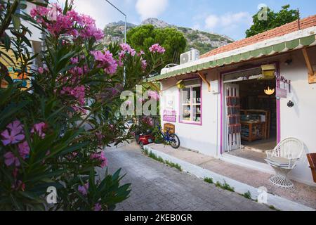 Kas, Türkei - 08. Juni 2022. KAS Stadt gemütliche Straße. Überwuchert mit Blumen türkisches Dorf blühende Straße. Einkaufen in Kas Stockfoto