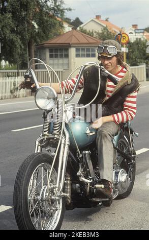 In der 1960s. Ein junger Mann auf seinem Harley Davidson Motorrad. Das Gesetz über das Tragen eines Schutzhelms ist noch nicht in Kraft und zu diesem Zeitpunkt war es beliebt, Lederkappen zu tragen. Schweden 1968 CV72 Stockfoto