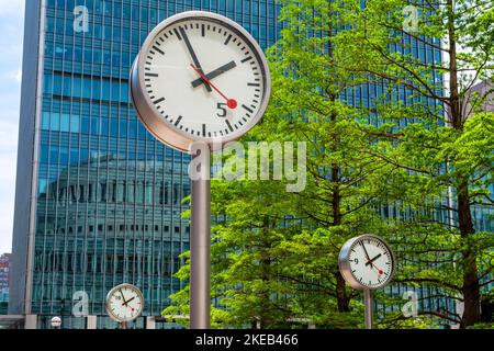 Öffentliche Uhren auf dem Platz in Canary Wharf. London, England Stockfoto