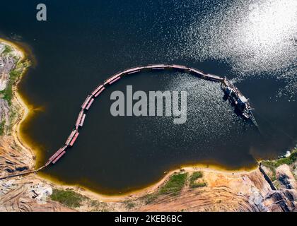 Saugrohrbagger in einer Sandgrube voller Wasser an sonnigen Tagen Stockfoto