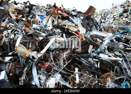 Großer Stapel verschiedener Abfallprodukte im Hof der Recyclinganlage Stockfoto