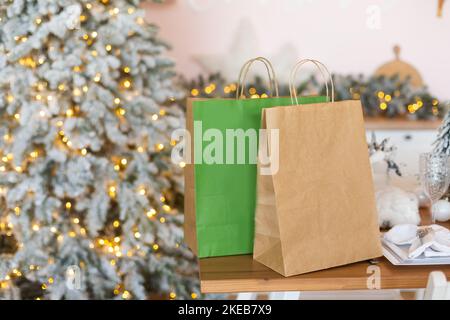 Die Lieferservice-Pakete stehen auf dem zu Weihnachten geschmückten Küchentisch. Geschenke und Fertiggerichte werden geliefert und für das neue Jahr vorbereitet. Stockfoto